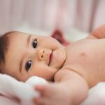 baby lying on pink bed