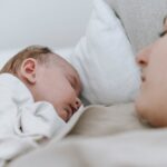 mother sleeping with newborn baby in bedroom